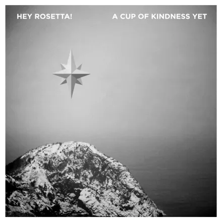 A compass star above a snow-covered headland, in black and white.